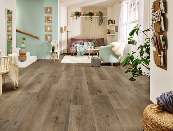 Helles Wohnzimmer mit Laminatboden der Serie 'Vinto', gemütlicher Sitzecke, Pflanzen und moderner Dekoration.