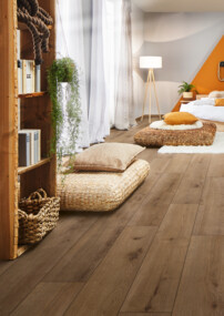 Gemütliches Schlafzimmer mit hellem Laminatboden, natürlicher Dekoration und warmen Farben.