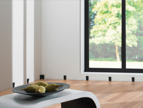 Moderner Wohnraum mit hellem Laminatboden und stilvollem Tisch, durch großes Fenster erhellt.
