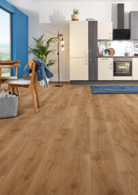 Moderner Küchen- und Essbereich mit hellem Laminatboden der Serie 'Aquaprotect Smart Silent' und blauer Wand, Holzmöbeln und großen Fenstern.
