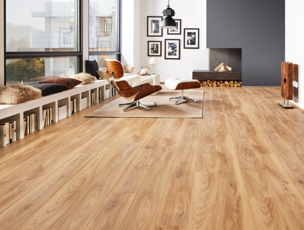 Modernes Wohnzimmer mit hellem Laminatboden, stilvollen Möbeln und großen Fenstern. Gemütliche Sitzbank mit Kissen und Bücherregalen darunter.