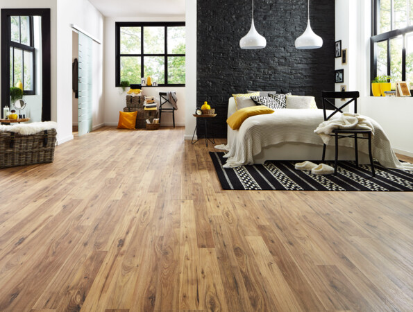 Modernes Schlafzimmer mit hellem Laminatboden, schwarzer Akzentwand, gemütlichem Bett und großen Fenstern für viel Tageslicht.