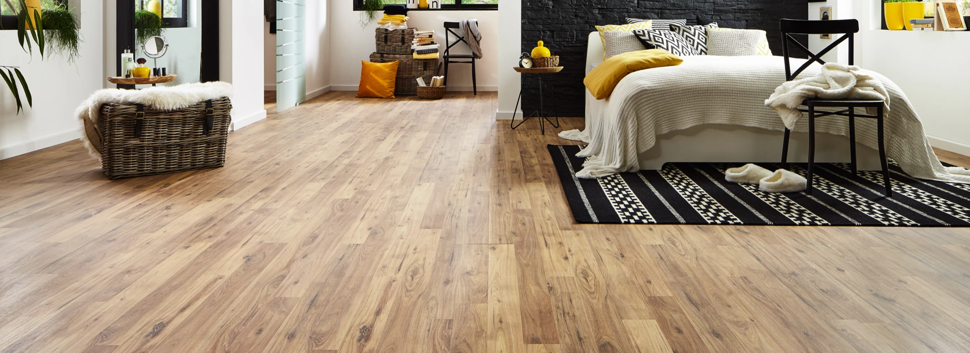Modernes Schlafzimmer mit hellem Laminatboden, schwarzer Akzentwand, gemütlichem Bett und großen Fenstern für viel Tageslicht.