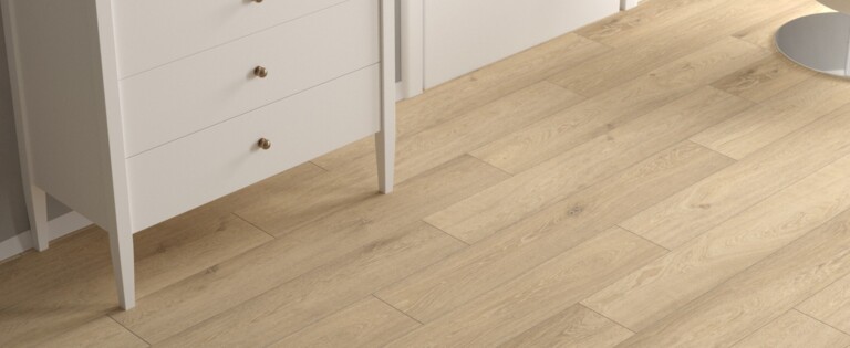 Moderner Raum mit hellem Laminatboden, weißer Kommode und Stuhl.