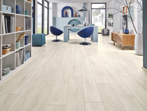 Heller Raum mit stilvollem Laminatboden, blauem Tisch, Regalen und Dekorationen.