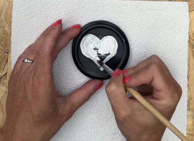 Eine Holztafel mit dem Text "Let's go for a walk", daneben wird ein Herz auf eine schwarze Fläche gemalt.