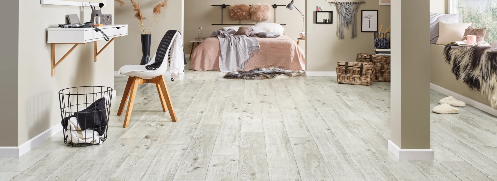 Moderner Raum mit hellem Laminatboden, gemütlicher Einrichtung und Dekoration. Schlafzimmer im Hintergrund mit Bett und Wanddekorationen.