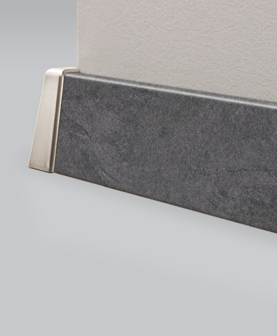 Ansicht einer Sockelleiste in dunkler Steinoptik an der Wand.