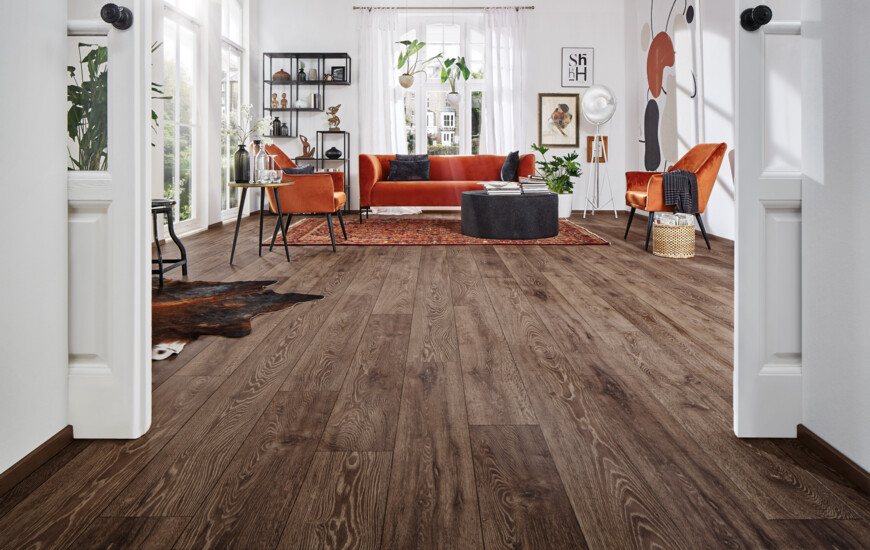 Wohnzimmer mit dunklem Laminatboden der Serie 'Aquaprotect', stilvollen Möbeln und moderner Dekoration.