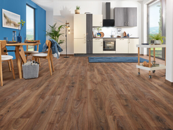 Moderne Küche mit Laminatboden, blauen Wänden und Holzmöbeln, die ein gemütliches Ambiente schaffen.