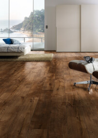 Moderner Raum mit stilvollem Laminatboden, Lounge-Stuhl und Meerblick im Hintergrund.