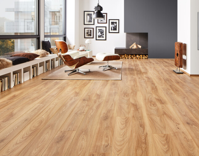 Modernes Wohnzimmer mit hellem Laminatboden, stilvollen Möbeln und großen Fenstern. Gemütliche Sitzbank mit Kissen und Bücherregalen darunter.
