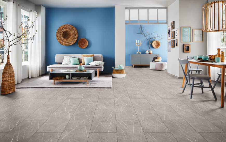 Living room with blue walls, grey laminate flooring, and a cosy seating area.