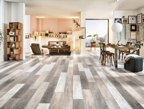 Bright living room with stylish laminate flooring, featuring a cosy seating area, dining table, and decorative shelving.