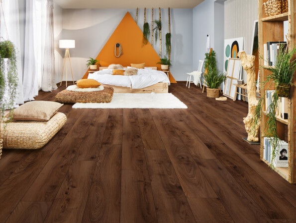 Gemütliches Schlafzimmer mit dunklem Feuchtraumboden, Pflanzen und heller Dekoration.