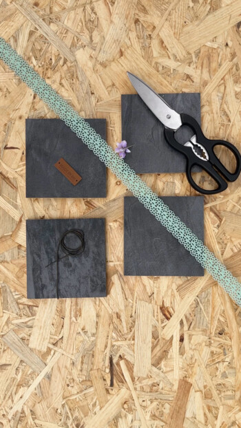 Schere, Spitzenband und quadratische Muster auf Holzuntergrund, passend für Laminatboden-Dekoration.