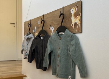 Kinderjacken hängen an einer Wand an einer DIY-Wandhalterung. 