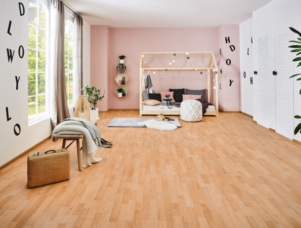 Helles Zimmer mit Laminatboden der Serie 'Family', einem Bett mit Rahmen, weichen Kissen und dekorativen Lichtern, großen Fenstern und Pflanzen.