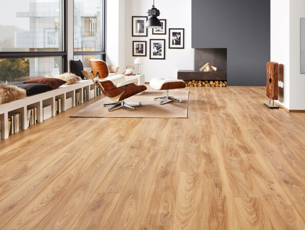 Modernes Wohnzimmer mit hellem Laminatboden, stilvollen Möbeln und großen Fenstern. Gemütliche Sitzbank mit Kissen und Bücherregalen darunter.