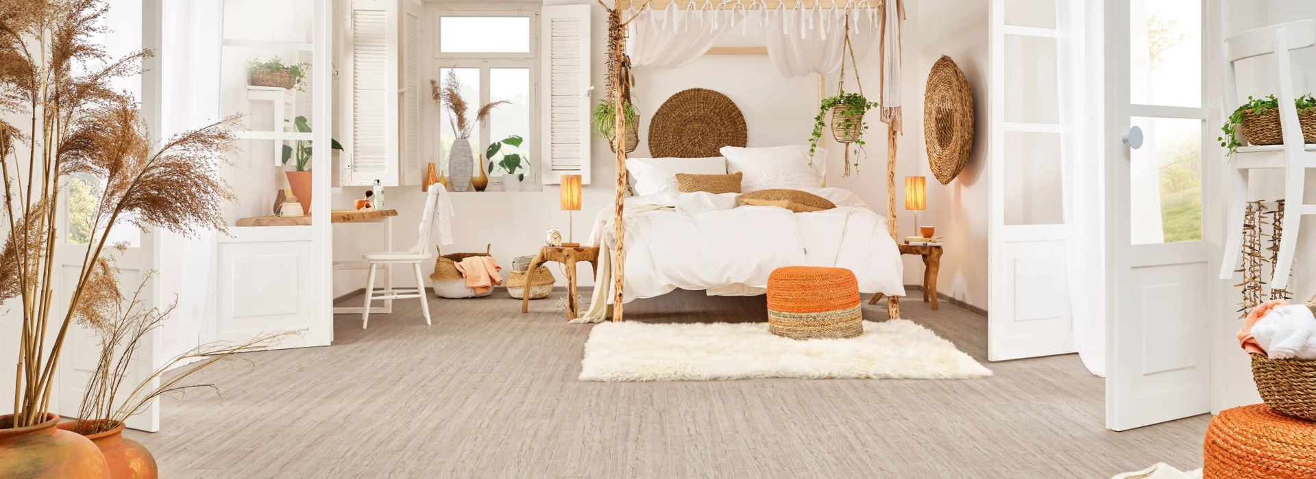 Bright bedroom with light laminate flooring, cozy decor, and natural accents.