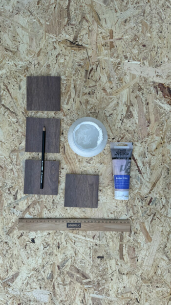 Holzproben, Stift, Lineal, Farbe und Binder auf OSB-Platte.
