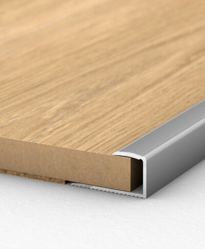 Laminatboden mit Aluminiumprofil an der Kante, zeigt Detail der Verarbeitung und Schutz.