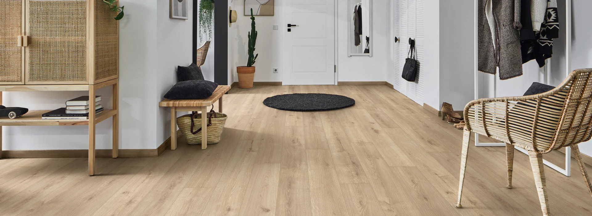 Moderner Flur mit hellen Laminatböden der Serie 'Aquaprotect', Rattanmöbeln und stilvoller Dekoration.