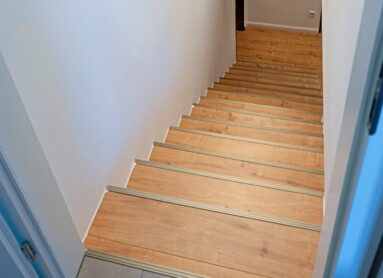 Dunkelbrauner Laminatboden in einem Musikstudio, das mit braunen edermöbeln ausgestattet ist.