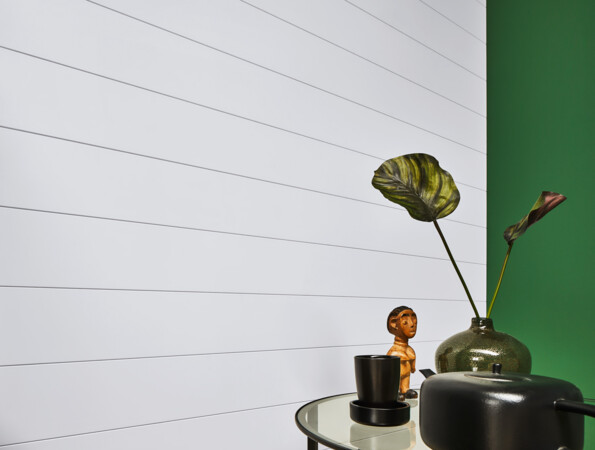 Decorative items on a table with a green and white panelled wall backdrop.