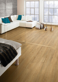 Helles Wohnzimmer mit modernem Laminatboden, weißen Möbeln und großen Fenstern.