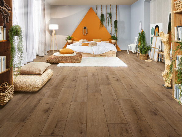 Gemütliches Schlafzimmer mit hellem Laminatboden, Bett, Pflanzen und dekorativen Details.
