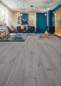 Moderner Wohnraum mit grauem Laminatboden, blauen Akzenten und stilvoller Einrichtung.