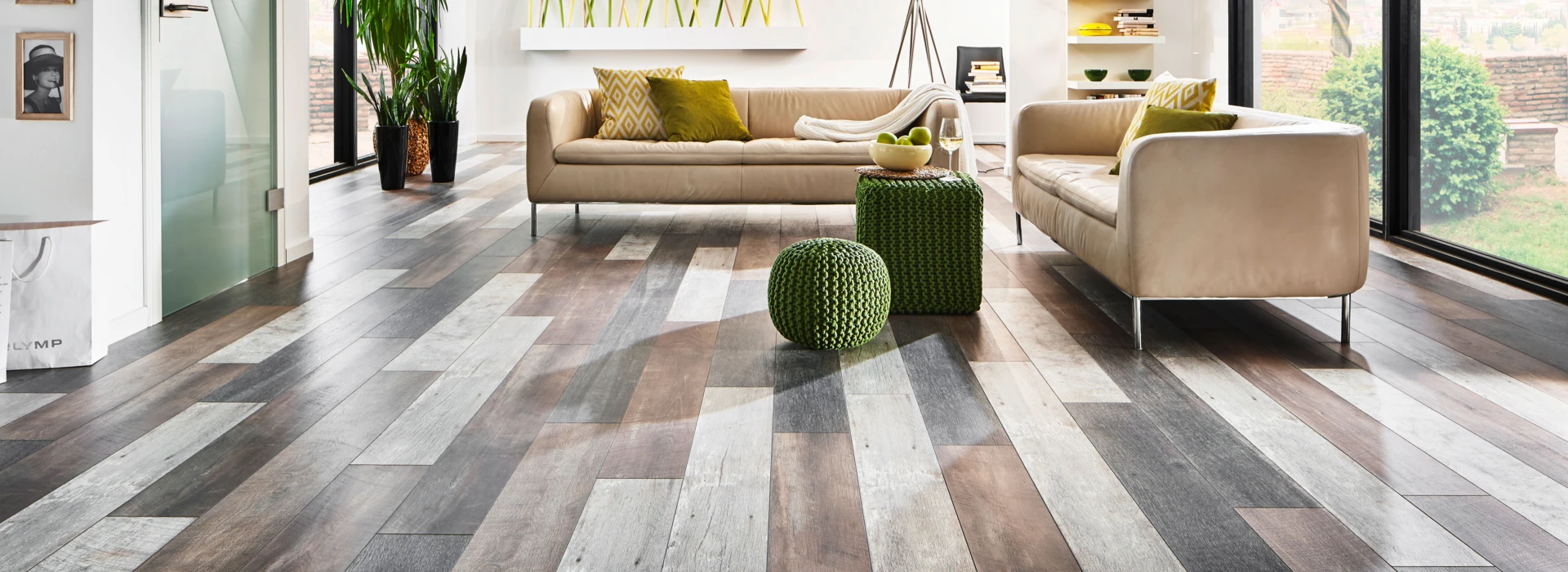 Moderner Wohnraum mit großen Fenstern, minimalistischer Einrichtung und stilvollem Laminatboden der Serie 'Vinto'