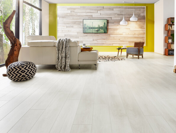 Living room with laminate flooring, white sofa, and wooden accents.