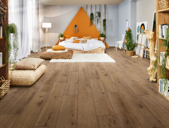 Gemütliches Schlafzimmer mit hellem Laminatboden, natürlicher Dekoration und warmen Farben.