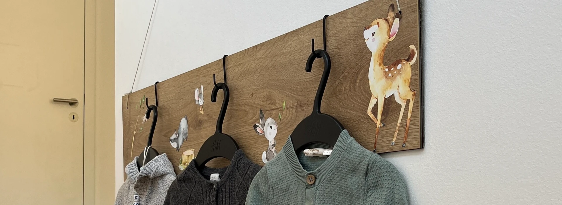 Kinderjacken hängen an einer Wand an einer DIY-Wandhalterung. 