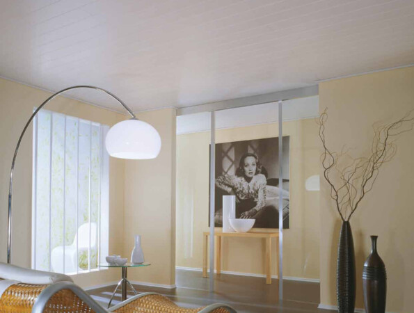 Modernes Wohnzimmer mit geschwungenem Rattan-Liege, großem Lampenbogen, Vasen und Kunstwerk an der Wand.