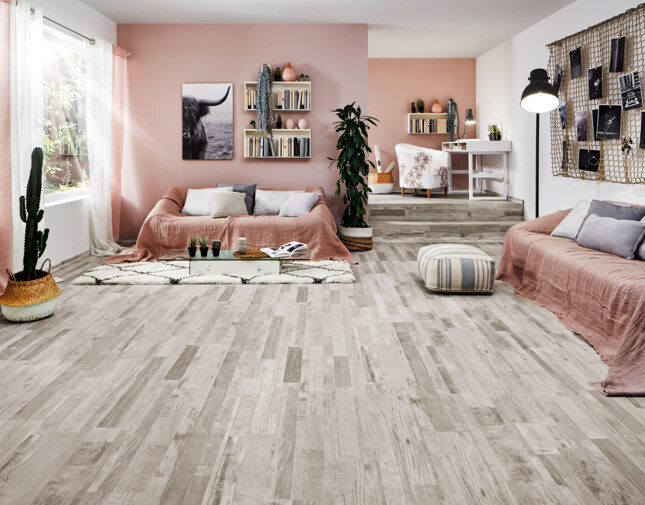 Living room with grey laminate flooring, pink accents, and cosy seating.