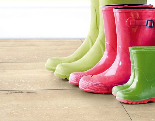 Colourful wellington boots on light laminate flooring.