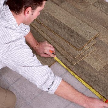 A man measuring laminate floor