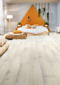 Modernes Schlafzimmer mit hellem Laminatboden, gemütlichem Bett, Pflanzen und Regalen, die eine einladende Atmosphäre schaffen.
