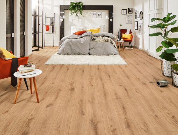 Bedroom with light laminate flooring, cosy bed, and vibrant decor, showcasing stylish interior design.