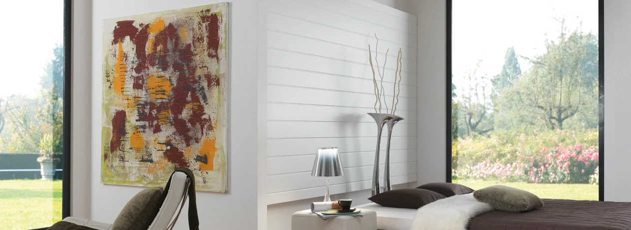 Bright room featuring a chair, abstract art, and large windows with a view, showcasing light laminate flooring.