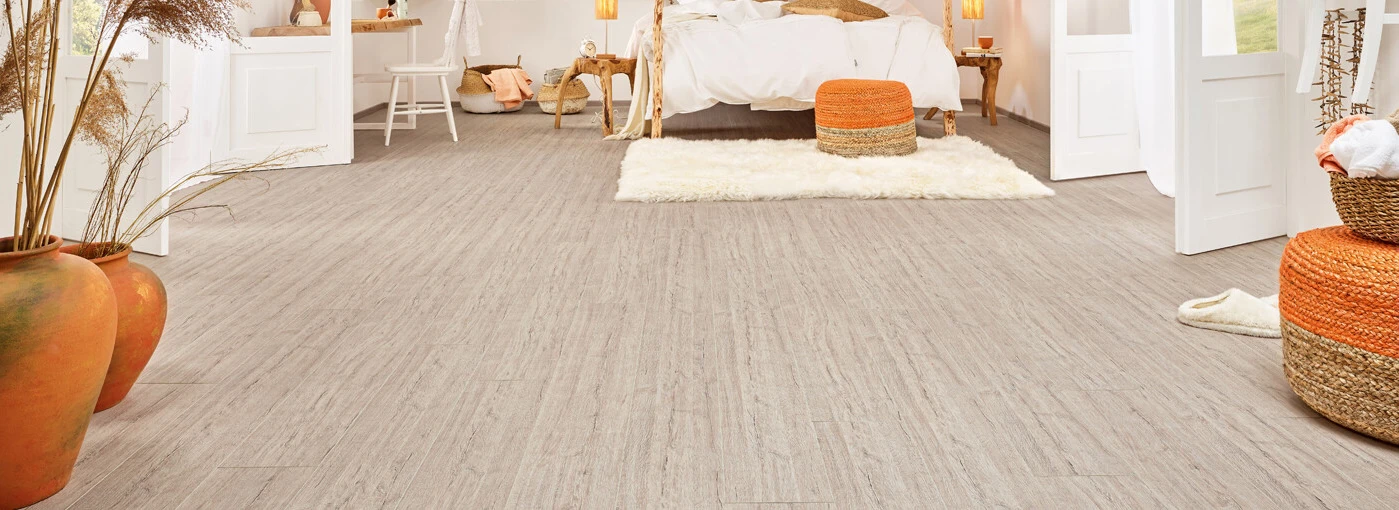 Helles Schlafzimmer mit gemütlichem Dekor, Pflanzen und modernem Laminatboden.