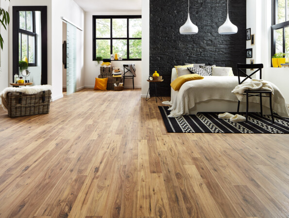 Modernes Schlafzimmer mit hellem Laminatboden, schwarzer Akzentwand, gemütlichem Bett und großen Fenstern für viel Tageslicht.