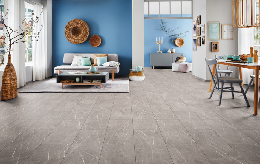 Living room with blue walls, grey laminate flooring, and a cosy seating area.