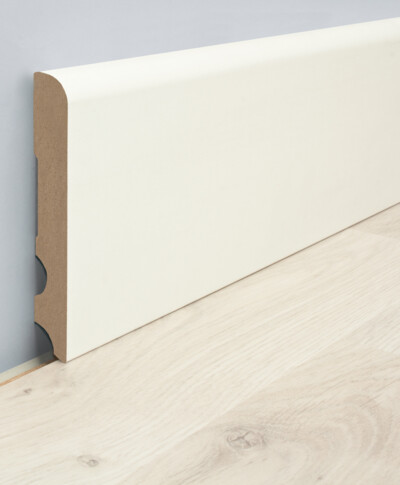 Weiße Sockelleiste an grauer Wand über hellem Laminatboden.