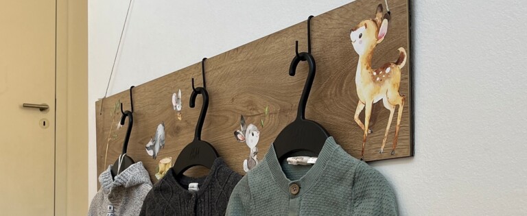 Kinderjacken hängen an einer Wand an einer DIY-Wandhalterung. 