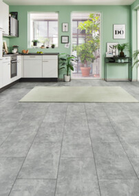 Moderne Küche mit grauem Laminatboden, hellen Wänden und grünen Pflanzen.