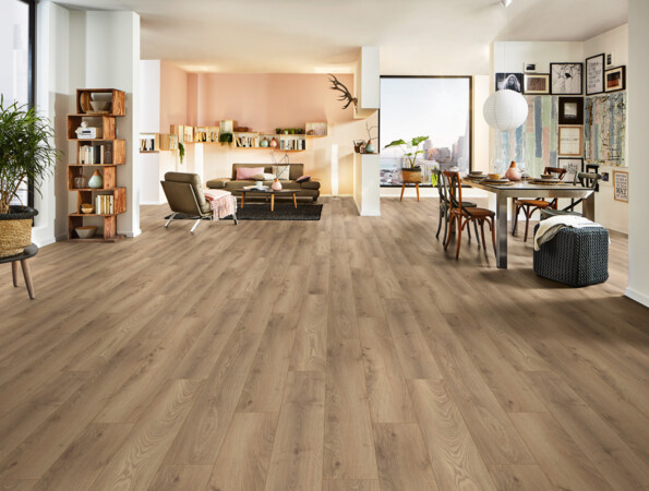 Ein modern eingerichtetes Wohnzimmer mit hellem Laminatboden der Serie 'Aquaprotect Smart Silent', Regalen, Esstisch und Pflanzen.